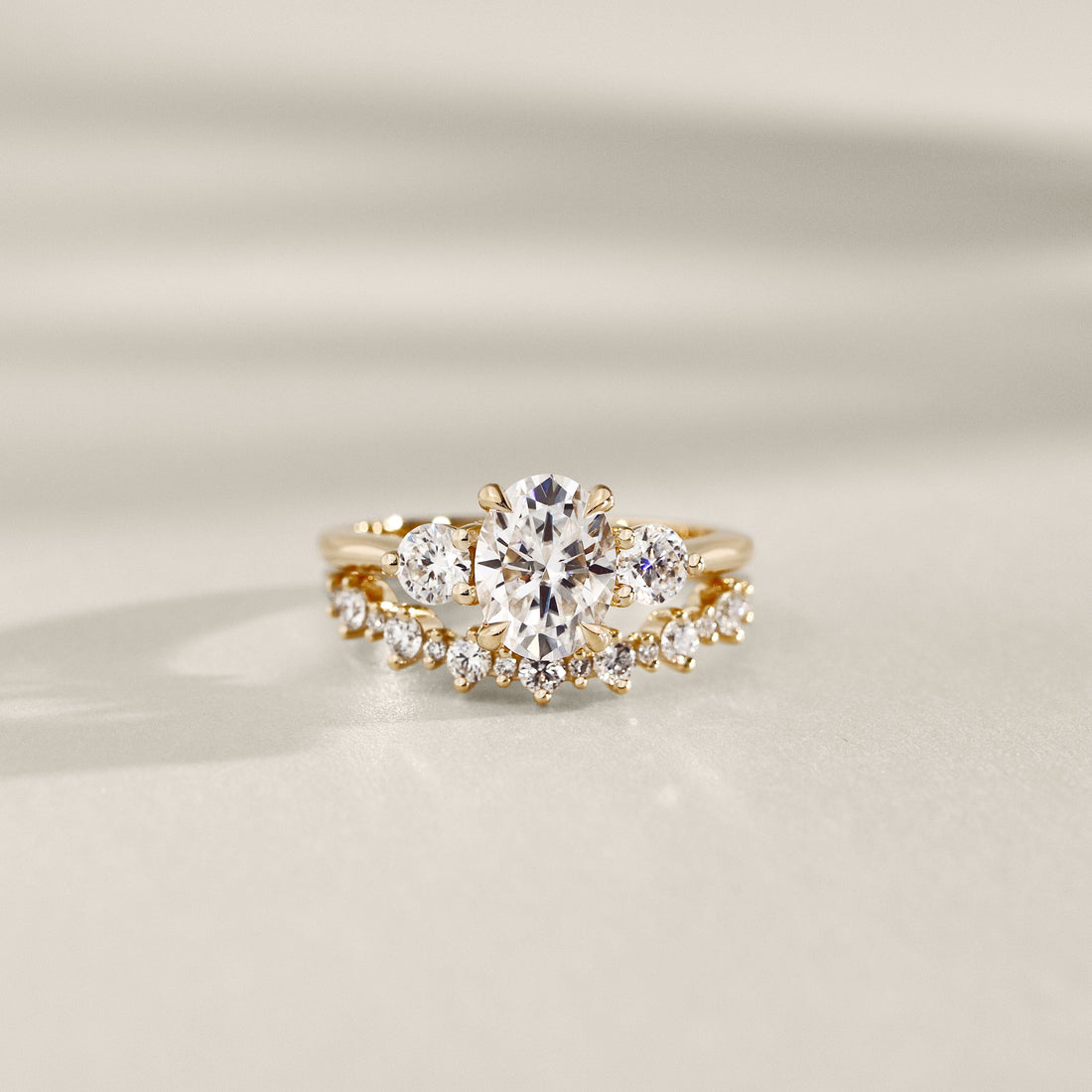 Oval cut lab grown diamond three stone ring with a curved band, sold separately